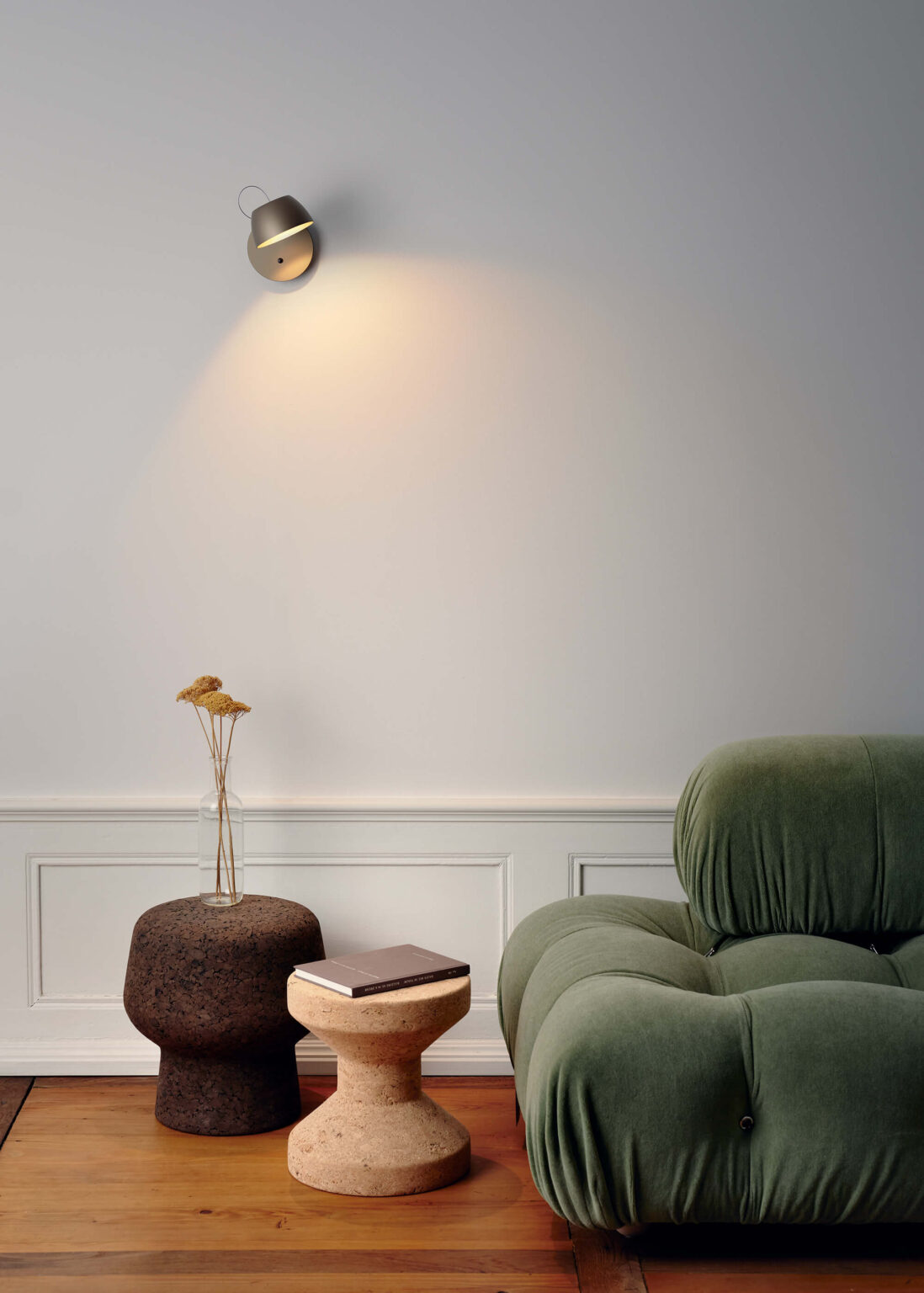 altensweiler Leuchte als Wandleuchte über grünem Sofa, mit zwei Beistelltischen und warmem Lichtkegel.