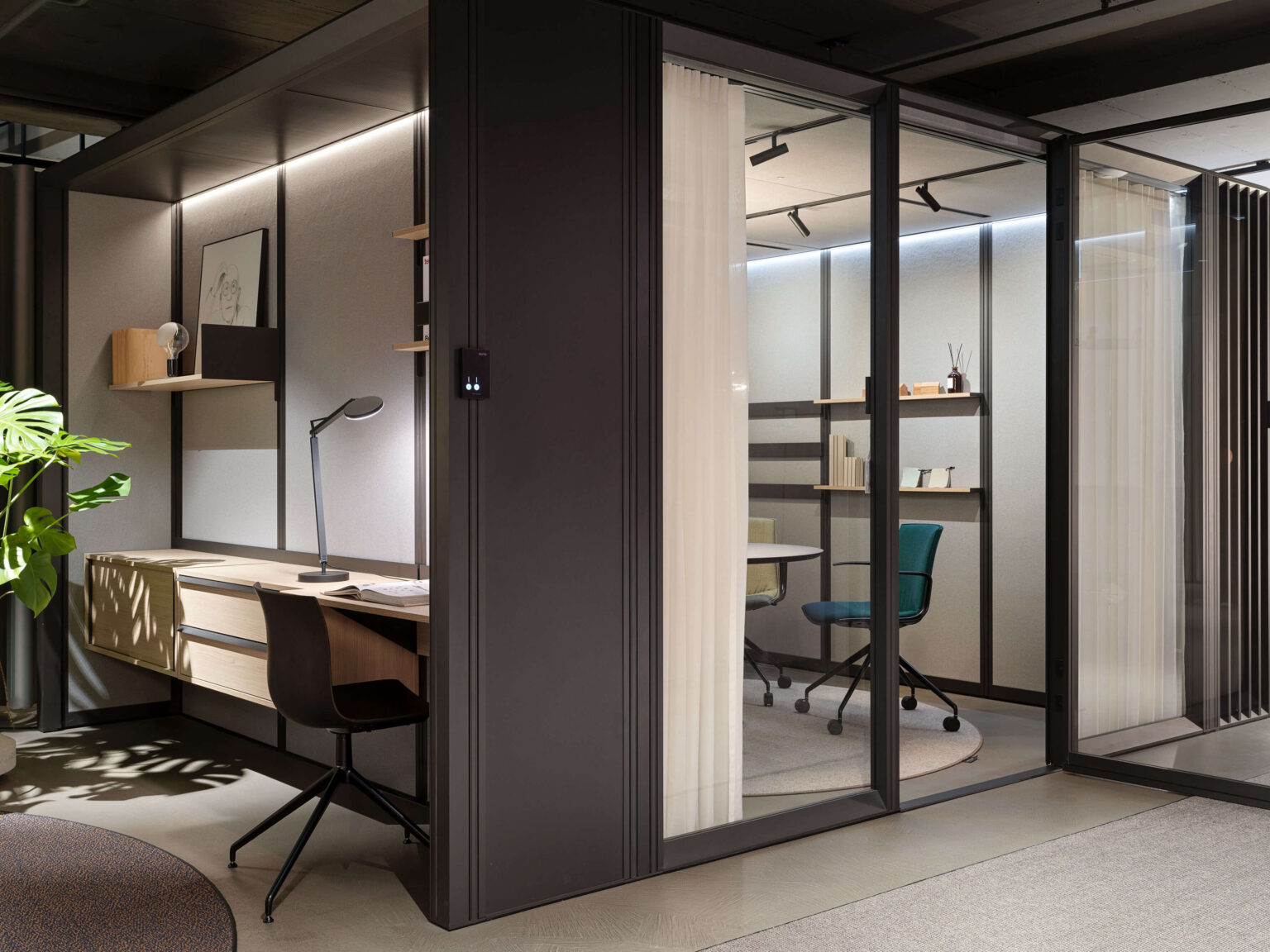 teo jakob Showroom, Gerechtigkeitsgasse 36 Bern, Arbeitsplatz mit Tischleuchte und Regalen neben einem verglasten Raum in Raum Bereich mit Stuhl.