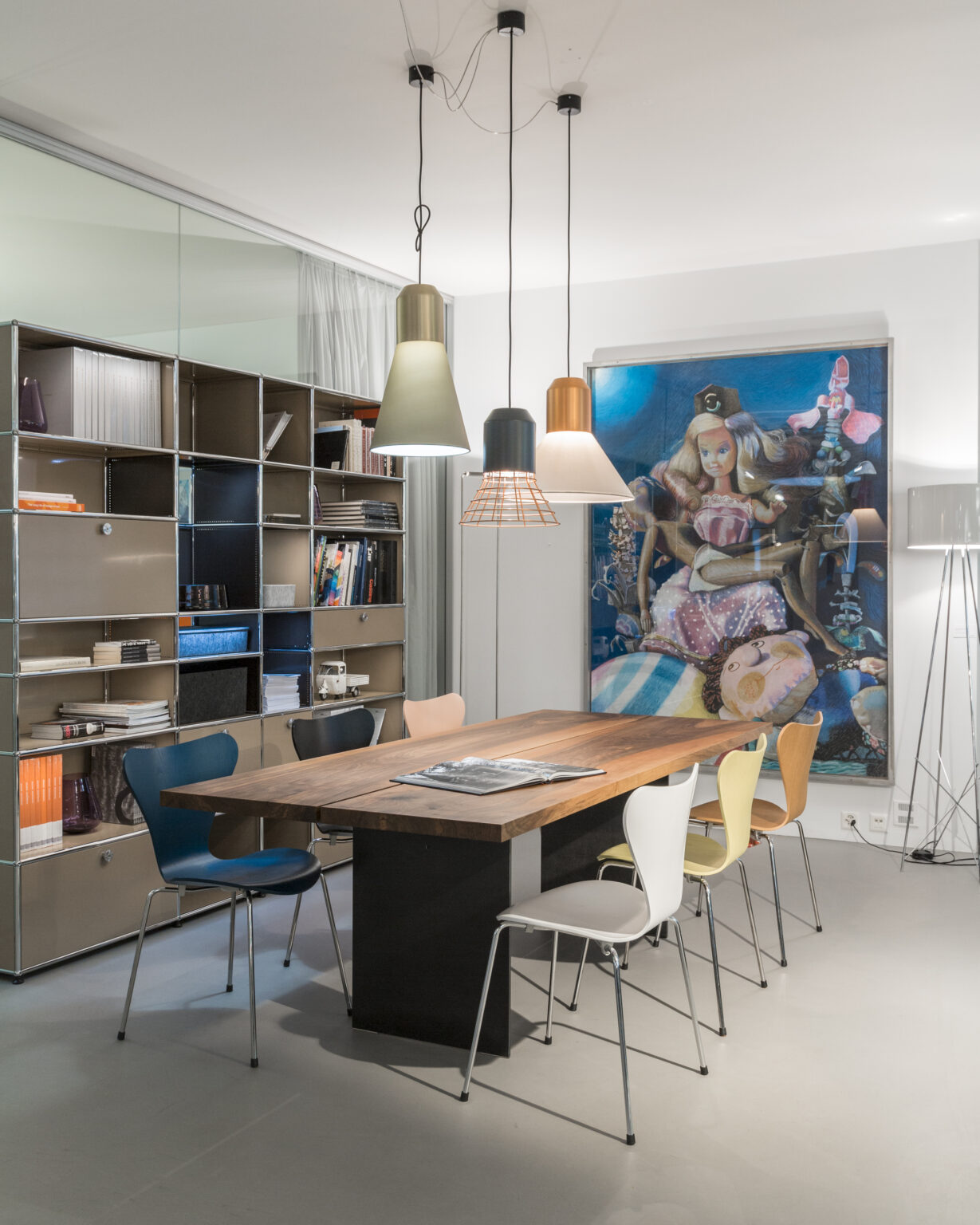 Besprechungsbereich im Showroom teo jakob Genf mit Holztisch, Design Stühlen und Pendelleuchten.