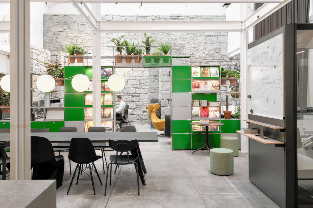 Grünes USM Regal mit integrierter Beleuchtung und Meetingbox im teo jakob Showroom Zürich.