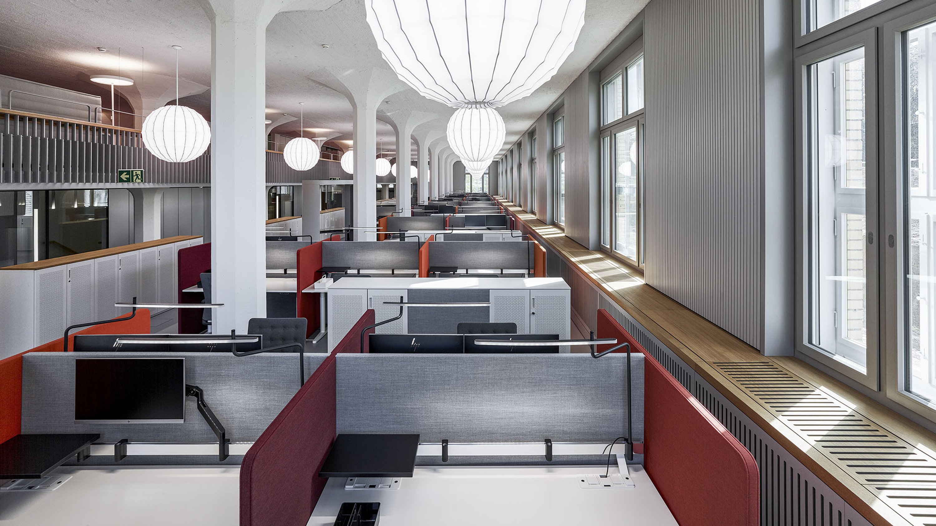 Grossraumbüro mit Arbeitsplatzreihen und Akustiktrennwänden, in einem Schweizer Bürokomplex.