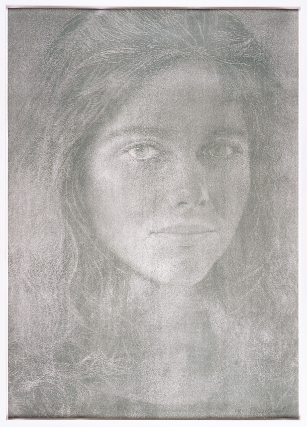 Schwarzweissporträt einer jungen Frau im Close-up. Ruhiger Blick, offenes gelocktes Haar, weiche Konturen auf heller Fläche.