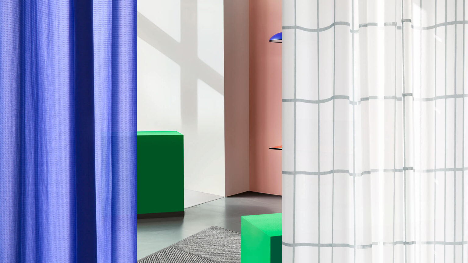 Farbige Vorhänge und geometrische Elemente in modernem Raum.
