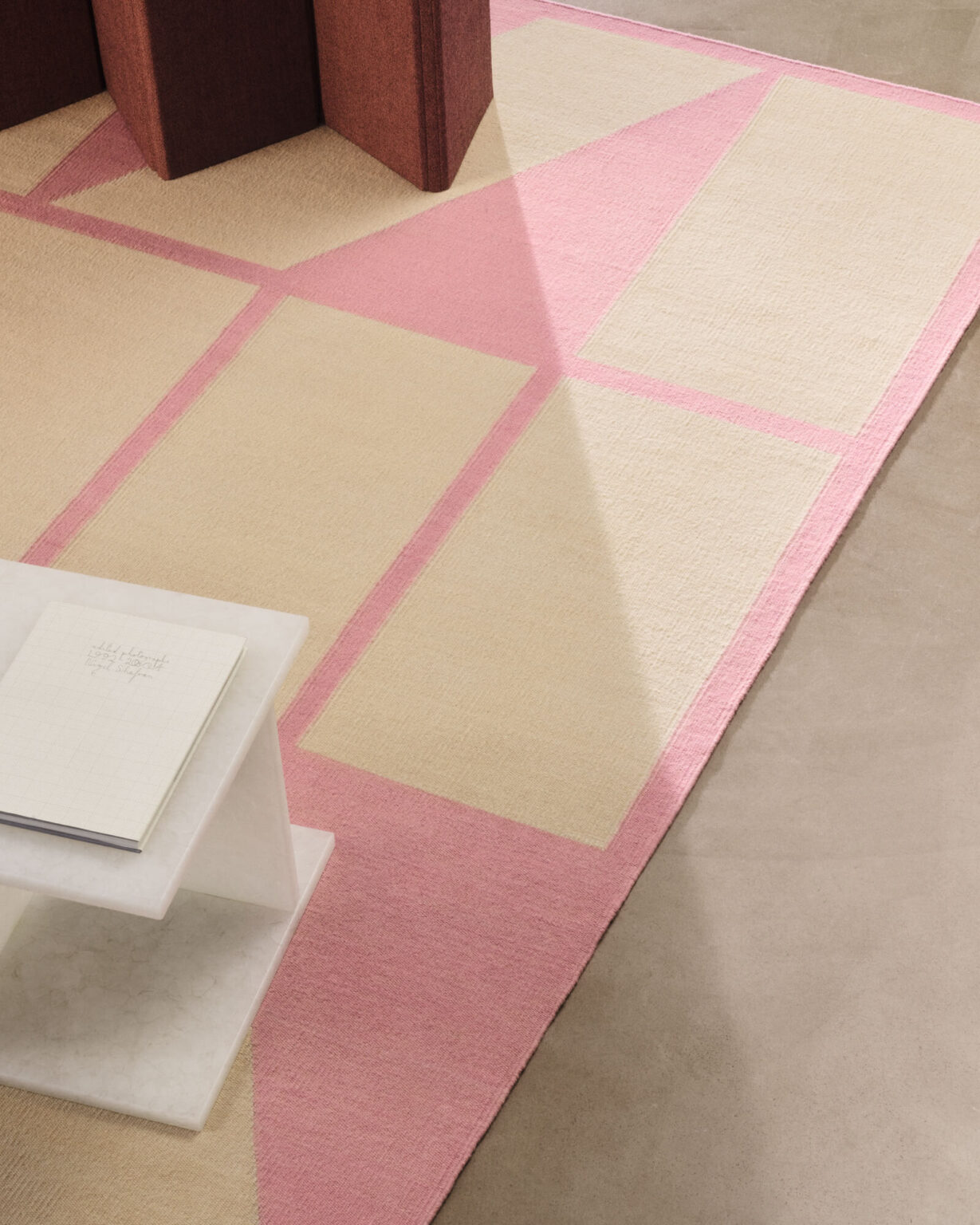 Teppich in Beige und Rosa mit geometrischem Muster.