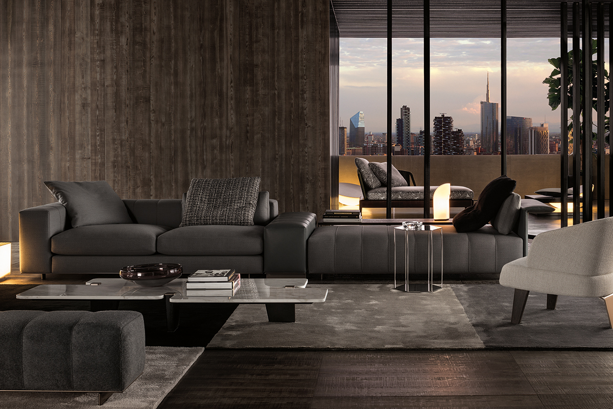 Grosszügiges, modern inszeniertes Wohnzimmer mit dunkelgrauem Sofa, niedrigem Couchtisch mit Büchern und Teppich, vor einer dunklen Holzpanelwand und bodentiefen Fenstern mit Blick auf Terrasse und Skyline bei Abendlicht.