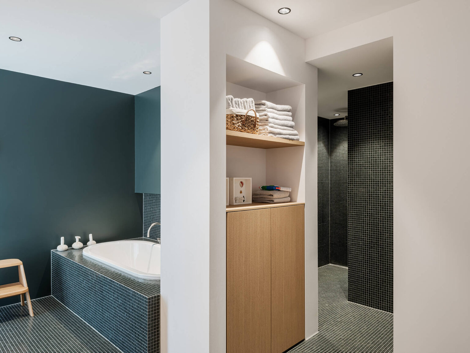 Begehbare Dusche mit dunklen Mosaikfliesen und Regendusche.
