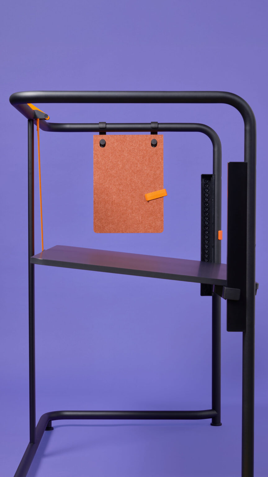Vitra Scout Edition Tisch mit Ablage und Filzpanel, schwarzes Gestell vor violettem Hintergrund.