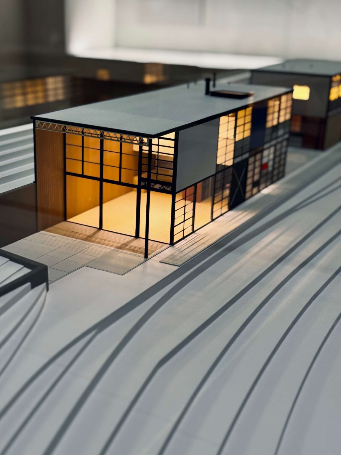 Architekturmodell eines modernen Hauses mit beleuchteten Innenräumen.