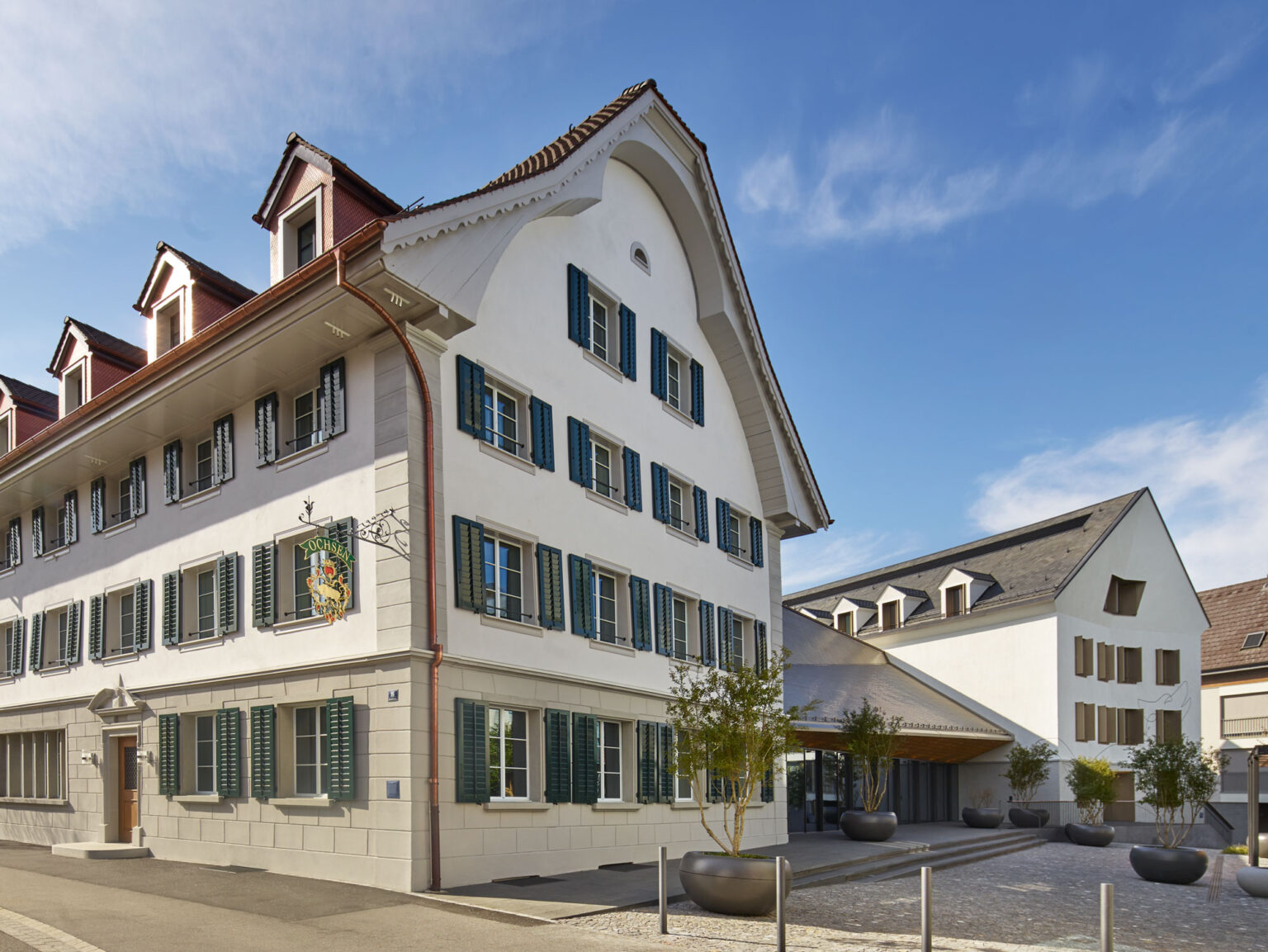 Historische Fassade des Restaurant Hotel Muri mit grünen Fensterläden.