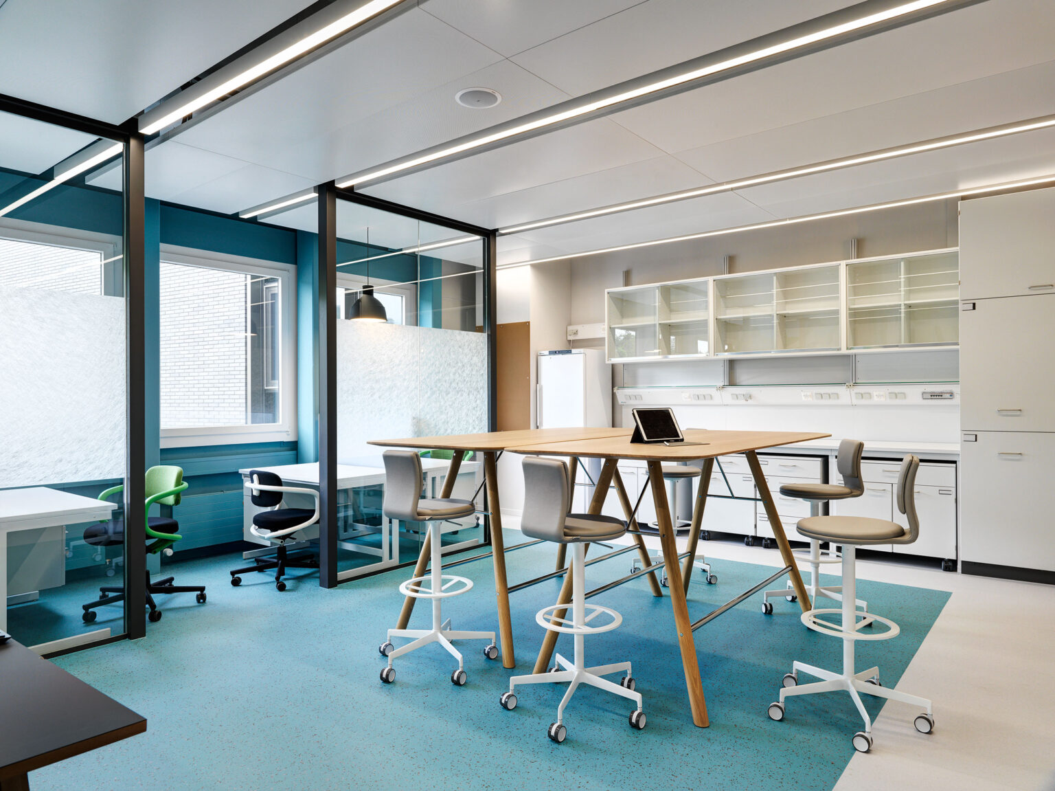 Labor- und Meetingraum mit Hochtisch und rollbaren Hockern im Givaudan Lab.
