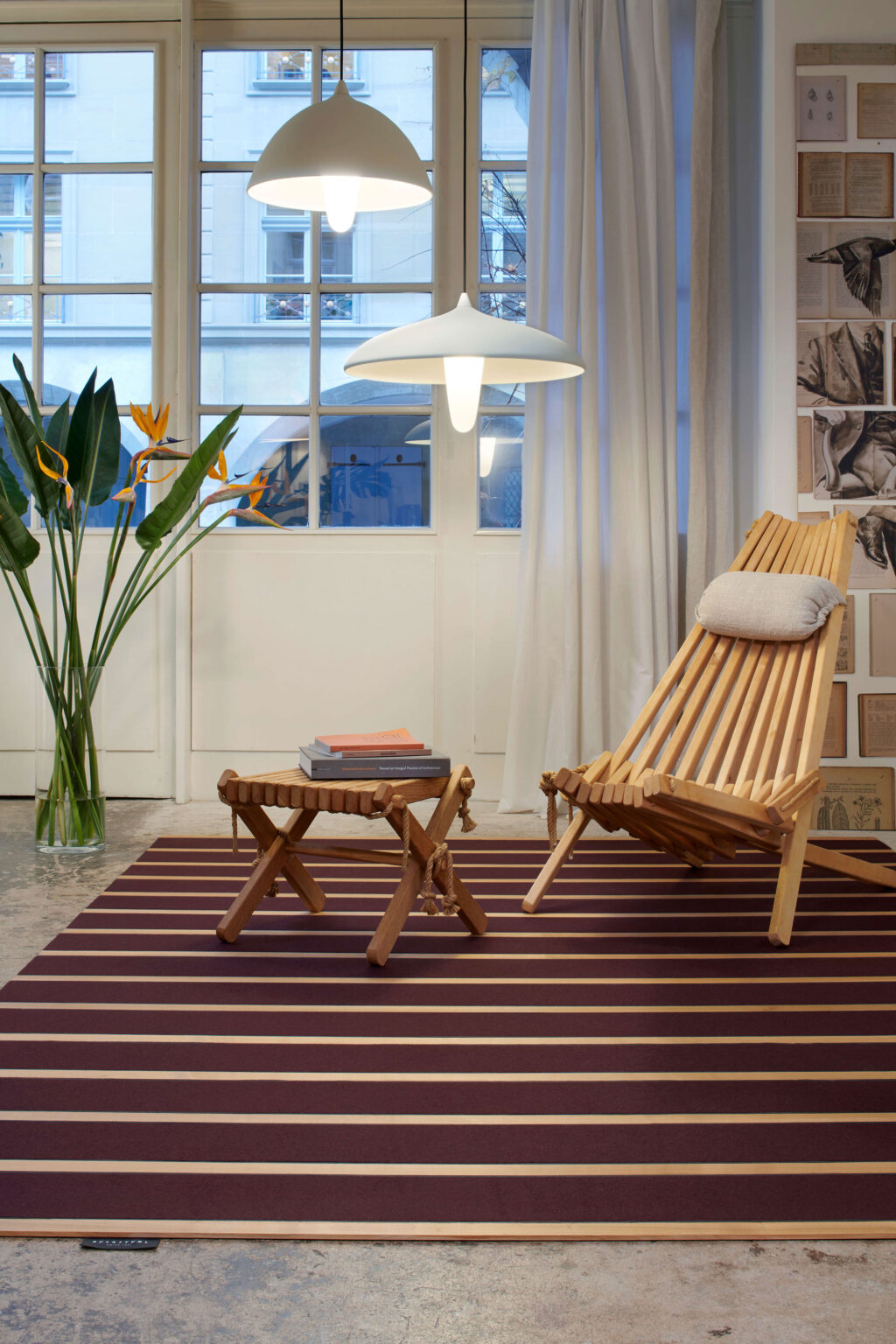 Arbeitsplatz mit Holztisch, schwarzen Bürostühlen und Wandlampen.