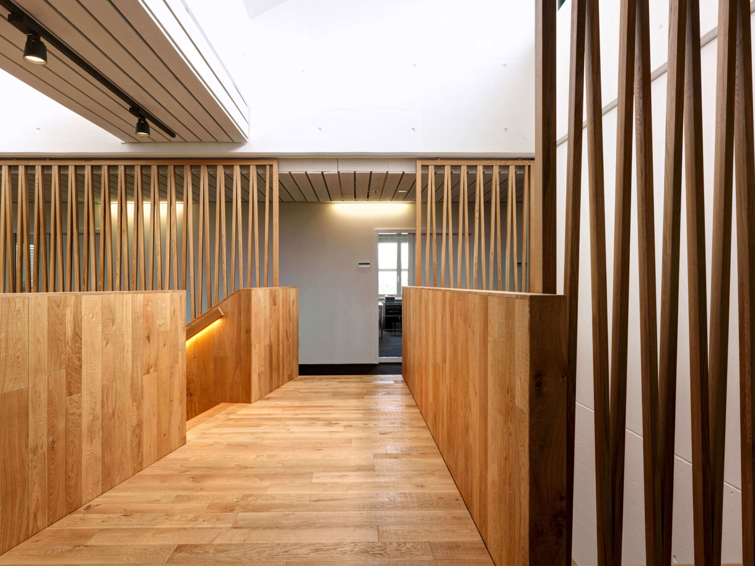 Migrolino Galerie mit Holzbrüstung und offenem Treppenbereich.