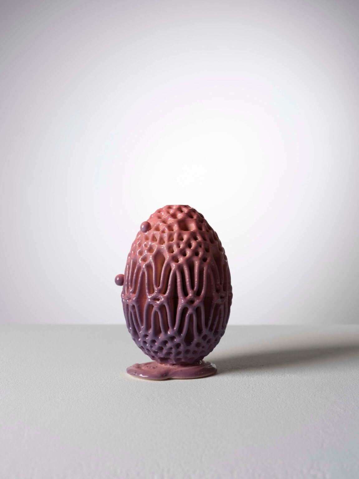 Eiförmige Keramikskulptur von Raphaël Emine mit violett glänzender Glasur, netzartiger Struktur und organischen Details.