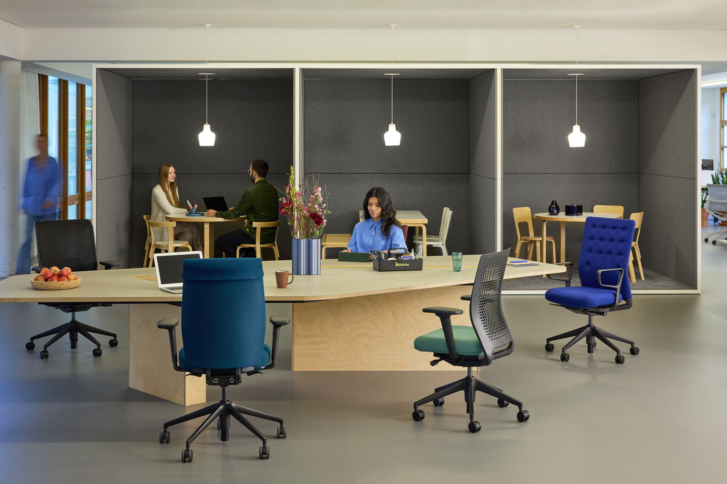 Vitra Büroeinrichtung mit offenen Arbeitsplätzen, akustischen Besprechungsnischen, verschiedenen Bürostühlen und zentralem Arbeitstisch in moderner Office Umgebung.