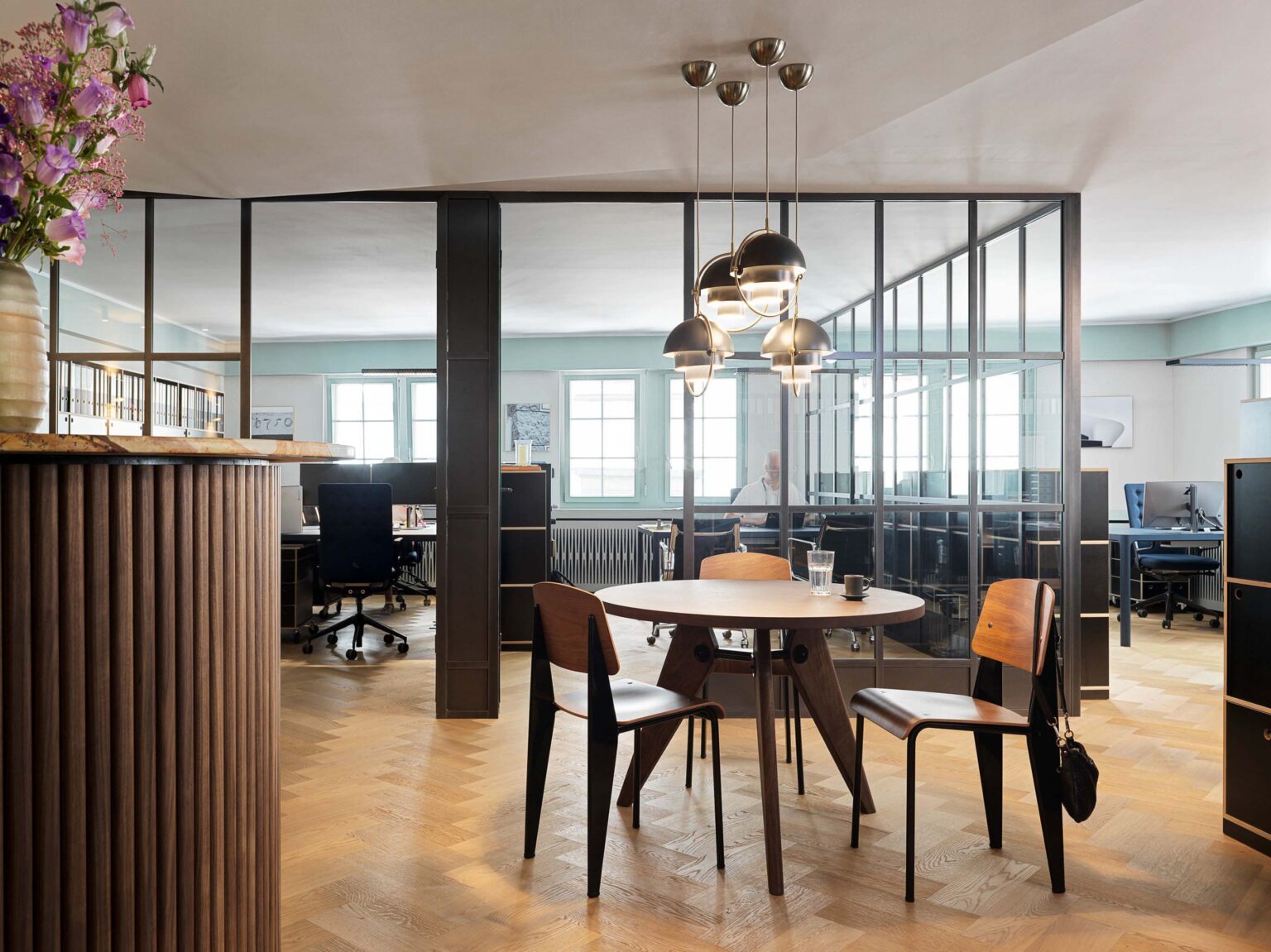 Büro mit raumhohem Regalsystem und schwarzem Schubladenmodul.